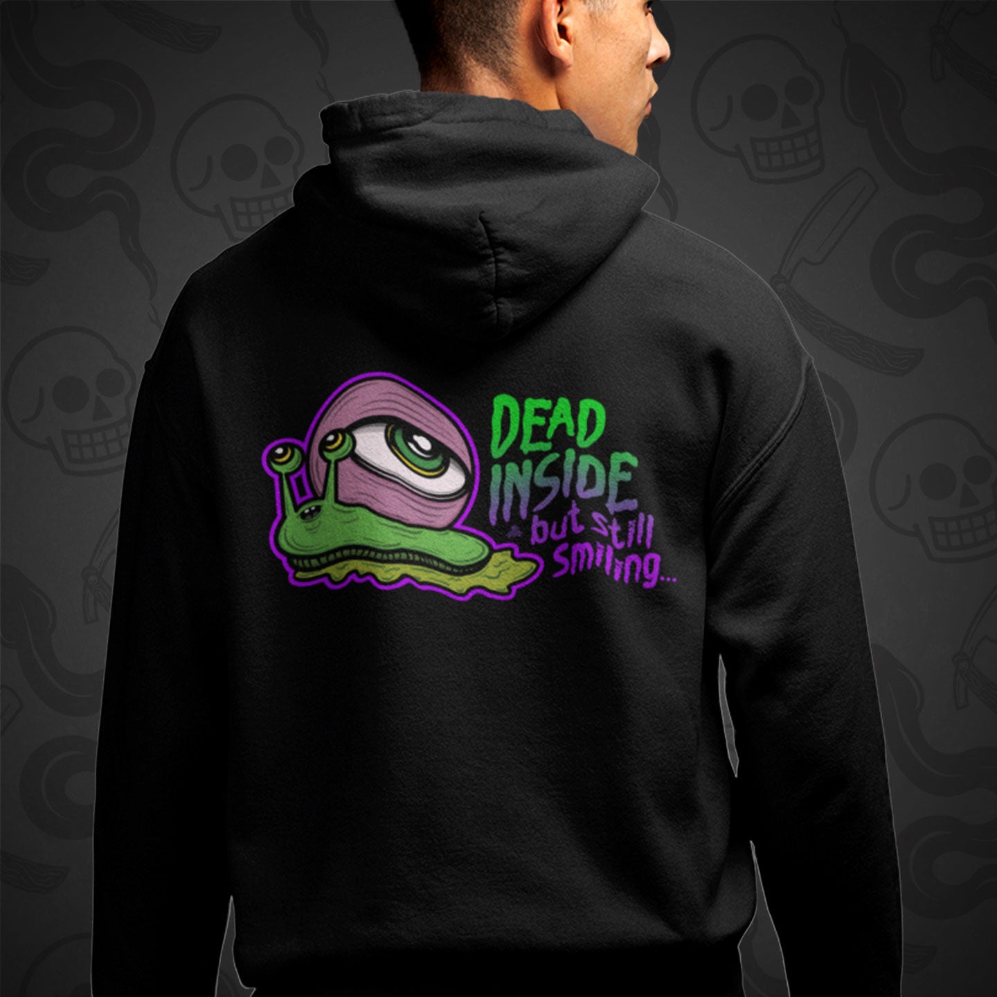 Cropped image of a Model wearing a black zippered hoodie with Dead Inside But Still Smiling design printed on the back with vibrant colors.