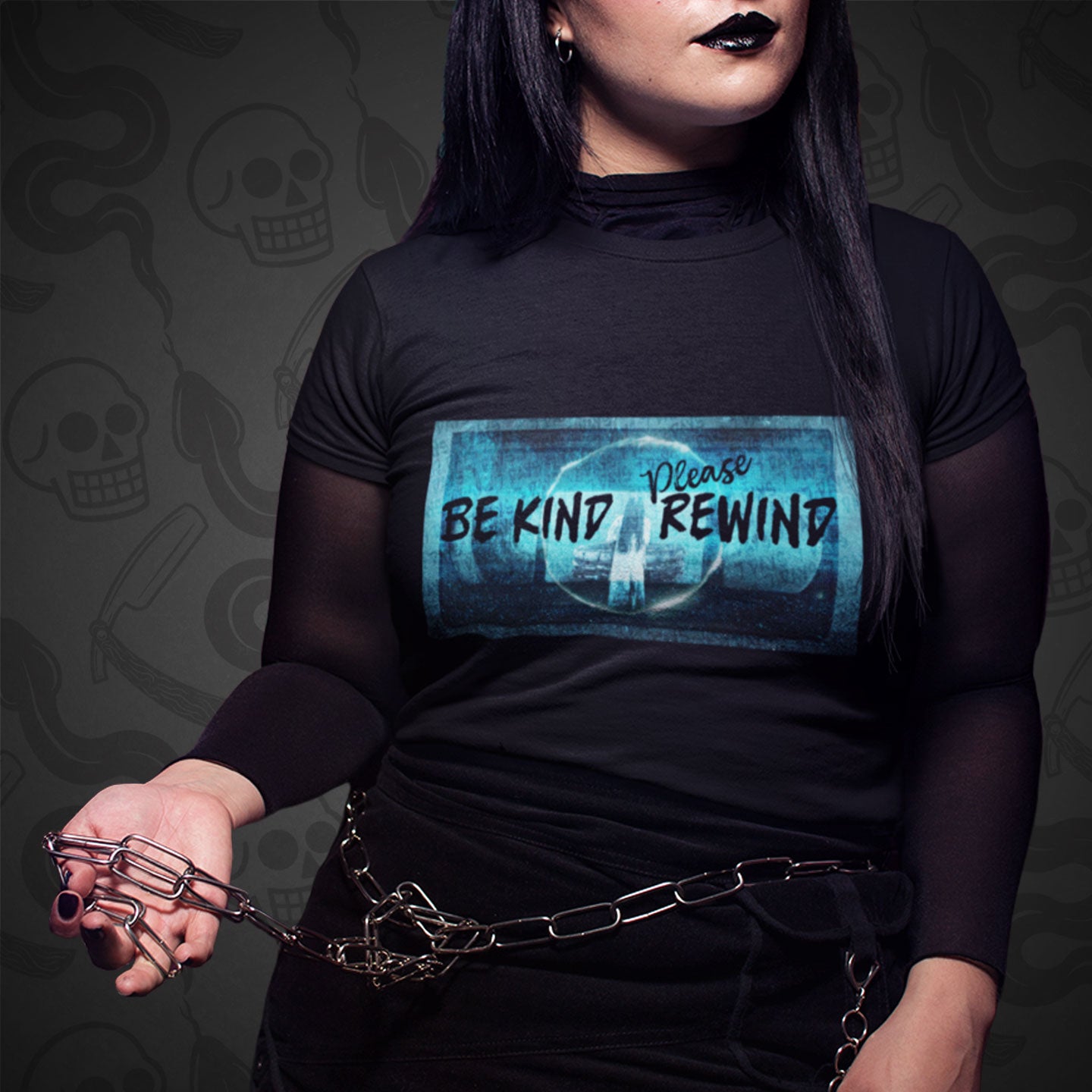 Cropped image of a model wearing black t-shirt with the Be Kind Please Rewind design printed on the front with vibrant colors.