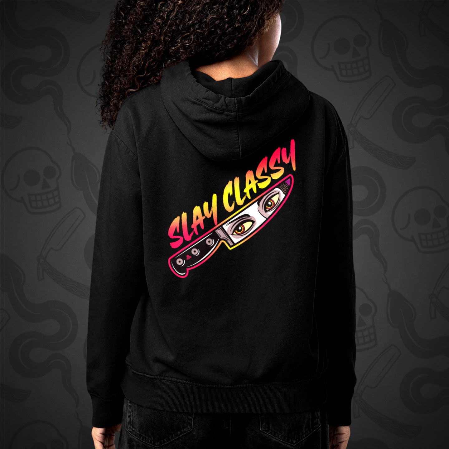 Cropped image of a Model wearing zippered hoodie with the Slay Classy design printed on the back with vibrant colors on patterned monochromatic background.