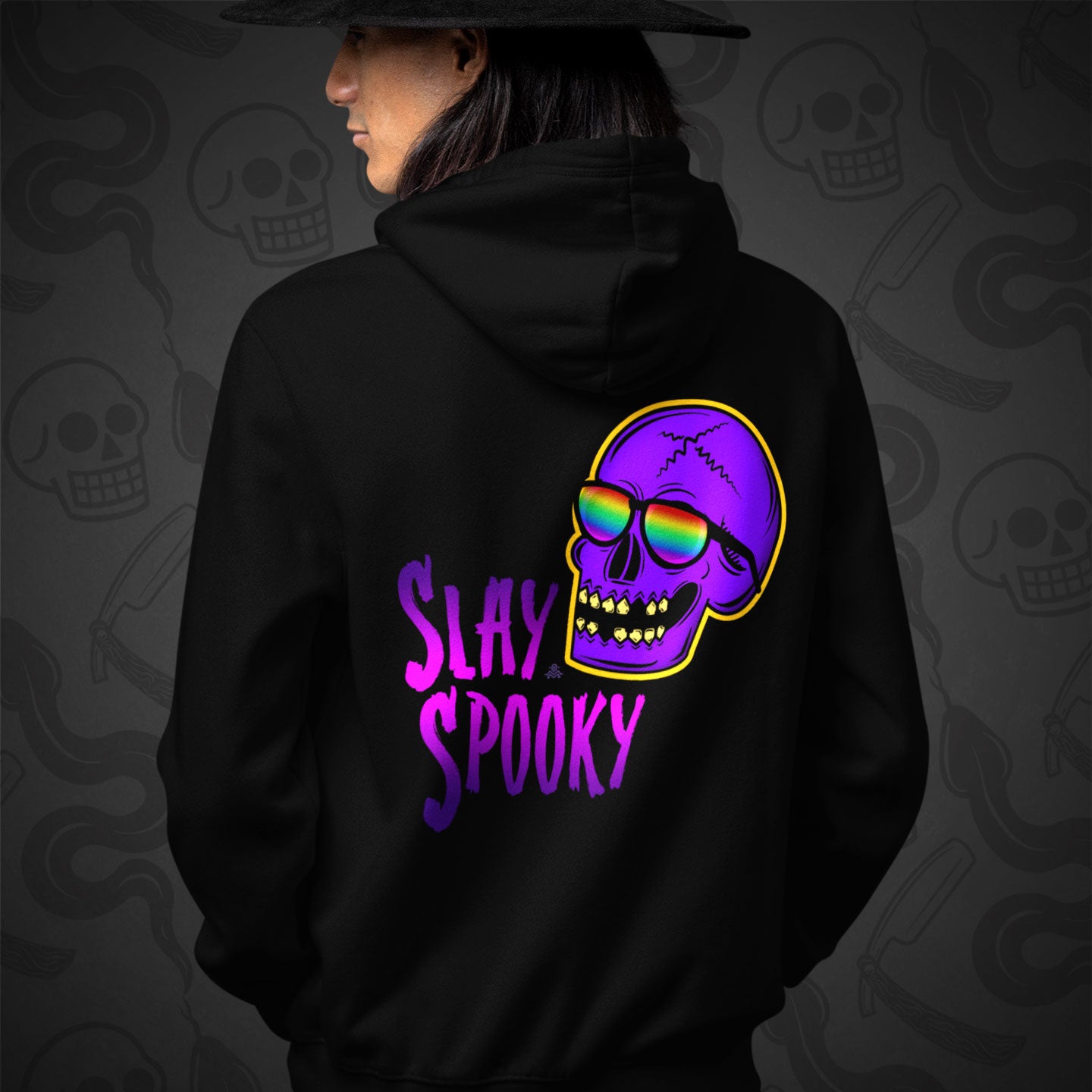 Cropped image of a Model wearing a black zippered hoodie with Slay Spooky design printed on the back with vibrant colors.